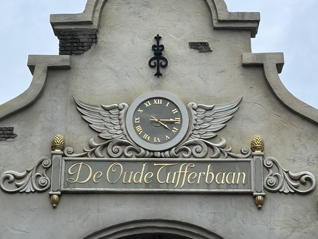 Klok met gevleugeld ornament boven de ingang van De Oude Tufferbaan in de Efteling