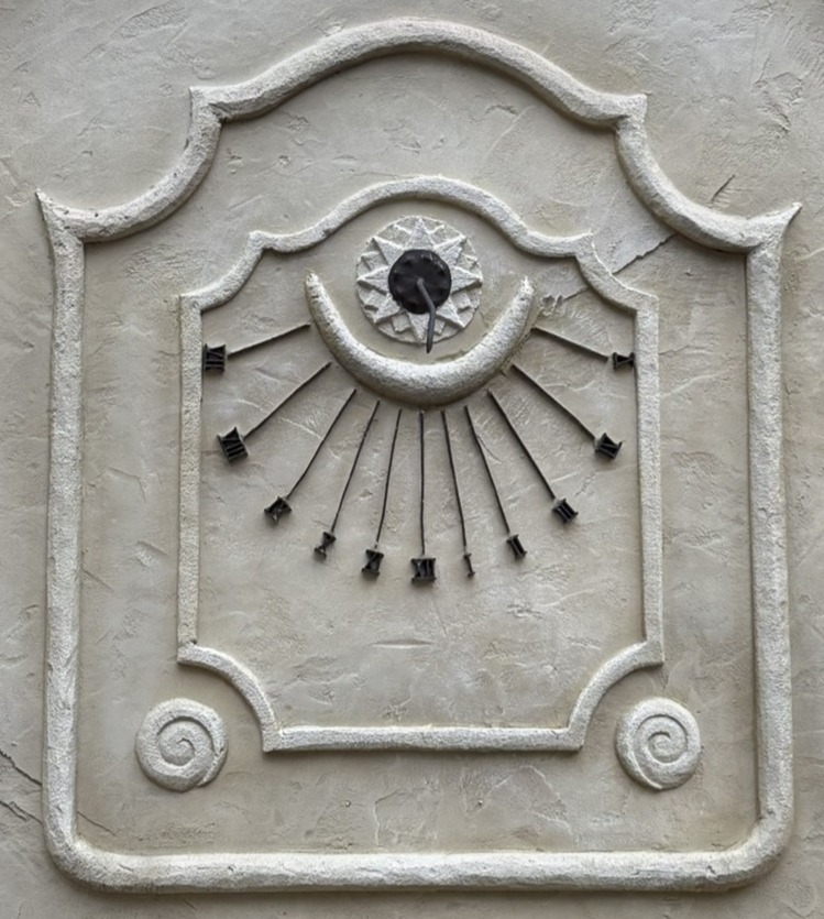 Verticale zonnewijzer op een pleisterwerk muur in de Efteling aan de PArdoes promenade